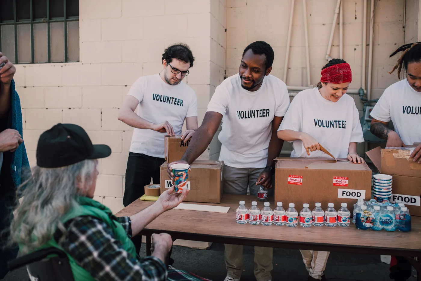 Volunteers distributing essential supplies during community service